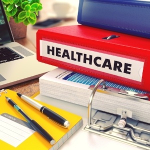 Healthcare - Red Office Folder on Background of Working Table with Stationery, Laptop and Reports. Business Concept on Blurred Background. Toned Image.-788642-edited.jpeg
