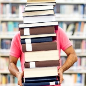 Male student carrying heavy books at the library-322416-edited.jpeg